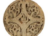 un objet en pierre orné d'un motif sur une surface blanche