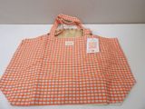 an orange and white checkered shopping bag sitting on a table