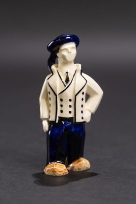 une petite figurine représentant un homme en costume et avec un chapeau