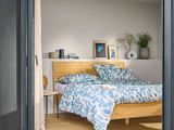 a bed in a bedroom with a wooden headboard and a blue comforter