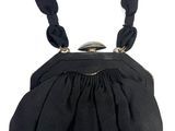 the black purse has a metal clasp on the handle