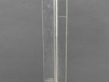 a glass vase with a wooden base on a table