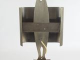 a metal sculpture of a surfboard on top of a wooden block