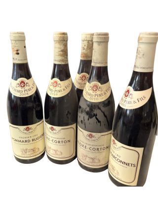six bouteilles de vin sont alignées sur une surface blanche