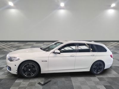 La BMW break blanche est garée sur un sol en carrelage à damier.
