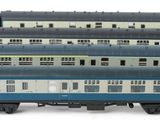 several blue and white train cars sitting next to each other on a white surface