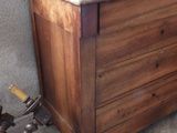 a wooden chest sitting on a tiled floor next to a wall