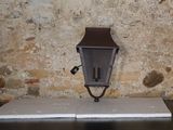 une lampe fixée sur le côté d'un mur de briques