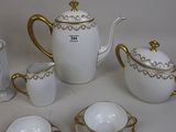 a white tea set with gold trimmings on it