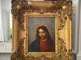 tableau représentant un homme barbu, dans un cadre doré, posé sur un comptoir en marbre