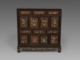 une commode ancienne en bois, avec des panneaux sculptés et des tiroirs