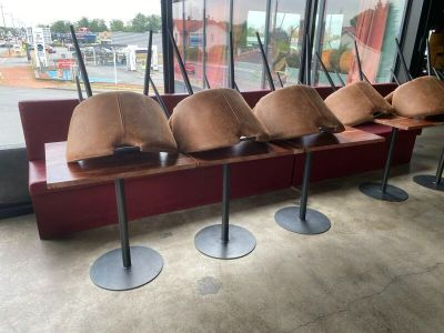 four hats sitting on a bench in front of a window