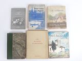 several books are lined up on a white surface with a white background
