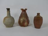 trois vases posés l'un à côté de l'autre sur une surface blanche