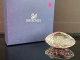 un cœur en cristal Swarooshi dans un coffret cadeau posé sur une table