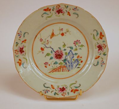 une assiette ornée d'un motif floral, posée sur un socle