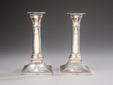 pair of antique silver candlesticks on a white background