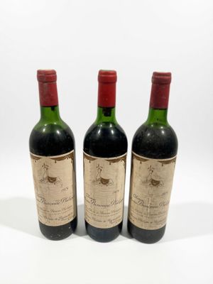 trois bouteilles de vin posées les unes à côté des autres sur une surface blanche