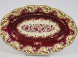 une image représentant une assiette rouge et dorée ornée d'un motif floral