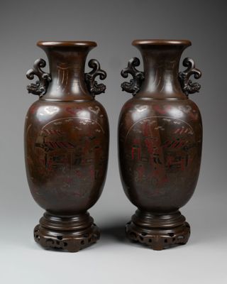 two brown vases sitting on top of each other on a gray surface