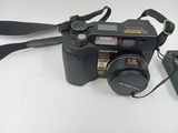 a black camera with a strap on it next to a cell phone