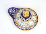 a blue and white teapot with a gold lid