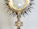 a gold and silver sunburst on a metal stand