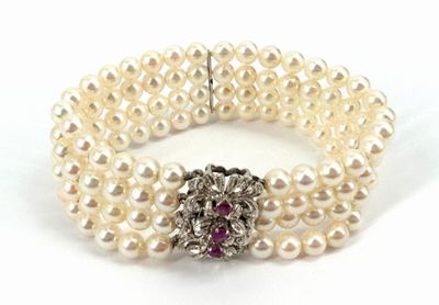 bracelet à trois rangs de perles, avec une pierre rose au centre et un fermoir en argent