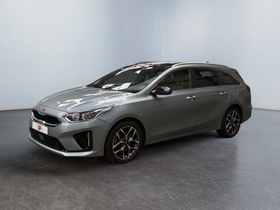 une voiture argentée garée dans une pièce aux murs blancs
