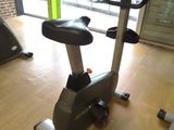 a stationary exercise bike in a gym with a monitor on the back