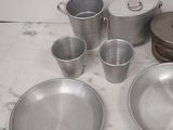 a lot of metal dishes and pans sitting on a counter