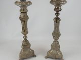 pair of antique silver candlesticks on pedestals on a white background