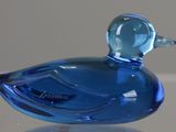 a small blue glass duck sitting on a table