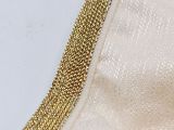 a close up of a gold chain on a white shirt