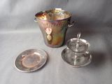 a silver cup and saucer sitting next to a silver plate