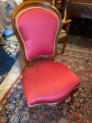 une photo d'une chaise rouge posée sur un tapis dans une pièce