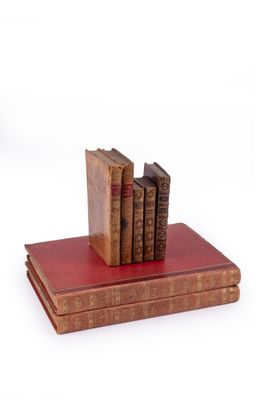 trois livres empilés les uns sur les autres sur un présentoir à livres