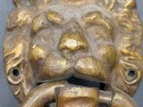 brass lion ' s head door knocket with a ring in the middle