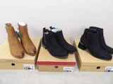 trois paires de bottes pour femmes sont posées sur des cartons