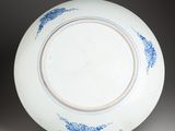 blue and white plate on stand on grey background with black background
