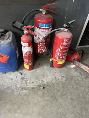 several fire extinguisors are lined up next to each other