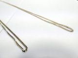 a close up of a silver chain on a white surface
