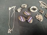 a lot of silver jewelry on a black table