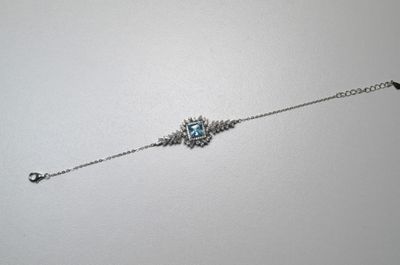 bracelet à chaîne en argent orné d'une pierre bleue et d'un oiseau