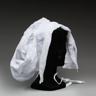 un gros plan sur une tête de mannequin recouverte d'un tissu blanc