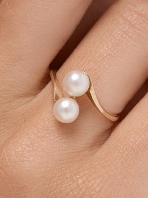 the pearl ring is on the finger of a woman ' s hand