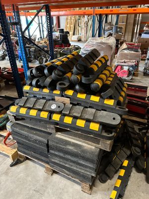 a pile of black and yellow pieces of equipment in a warehouse