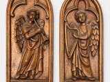 a pair of carved wooden plaques depicting angels