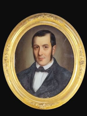 portrait d'un homme en costume et nœud papillon dans un cadre doré