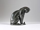 an image of a statue of a cat sitting on a white surface